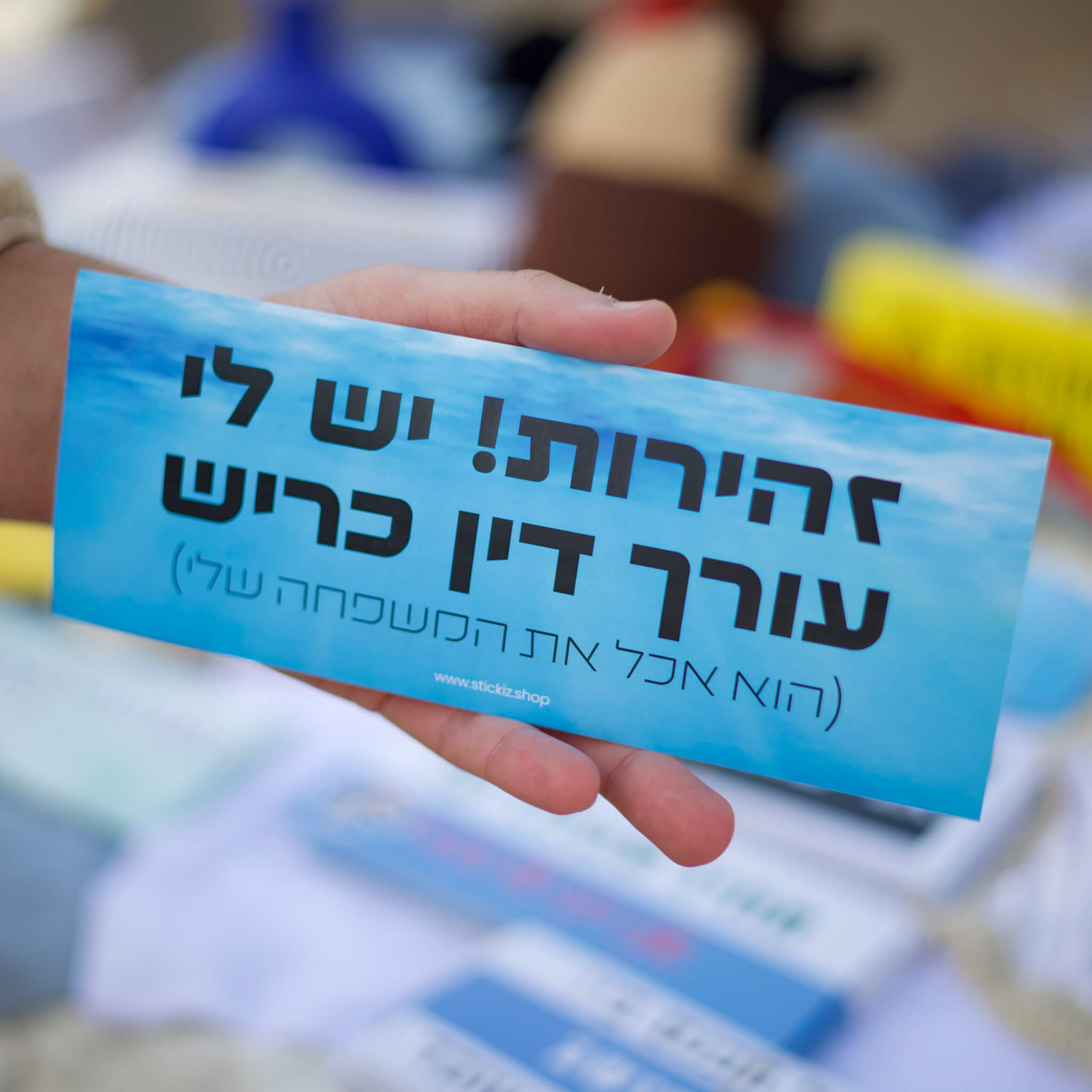 מדבקה לרכב זהירות יש לי עורך דין כריש, מוחזקת ביד